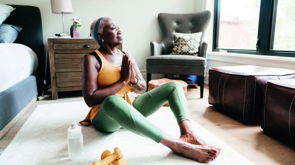 woman meditating on floor at home